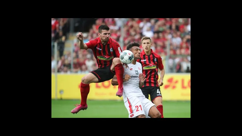 Cầu thủ Freiburg nỗ lực vượt qua phòng ngự của Mainz trong trận đấu